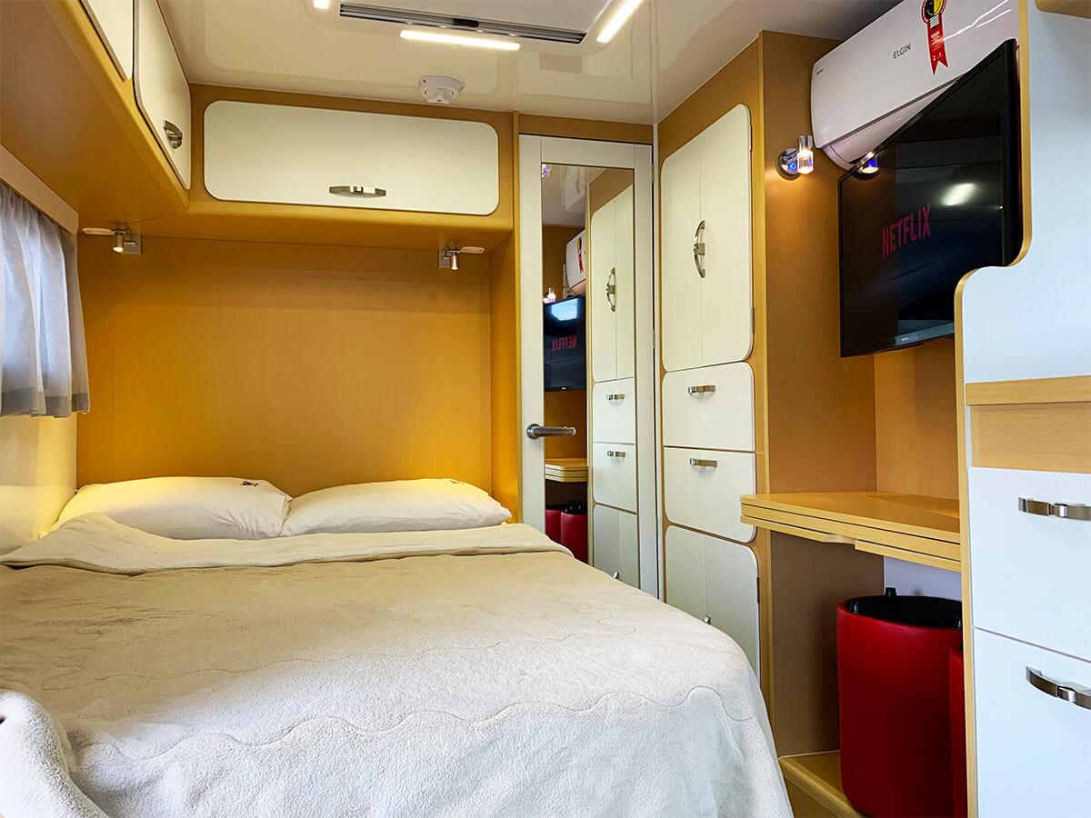 Detalhe do quarto do motorhome Apolo 6.0 com televisão e ar condicionado